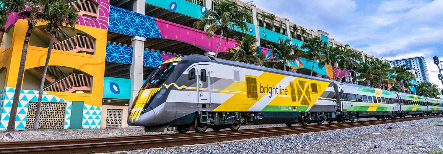 Brightline train against brightly colored building