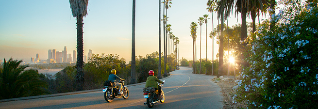 People on scooters with helmets