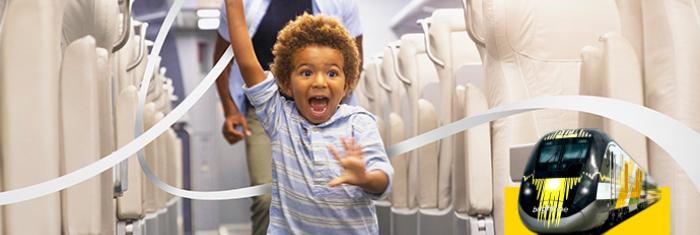 Boy running with man following in the aisle of a train